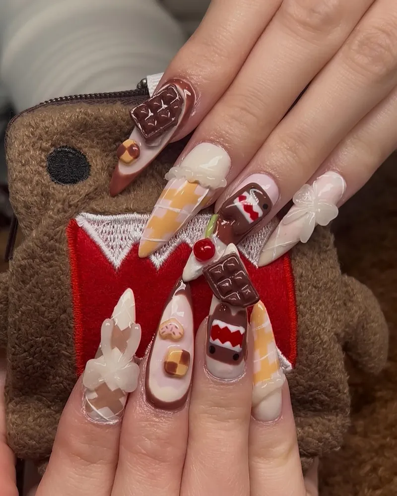 Domo-kun nails: 3D chocolate bars, cherries and Domo's face on long stilettos, next to a Domo plush