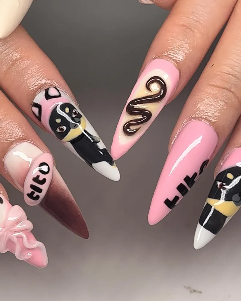 Pink and black almond nails with a brown snake, hearts and lettering