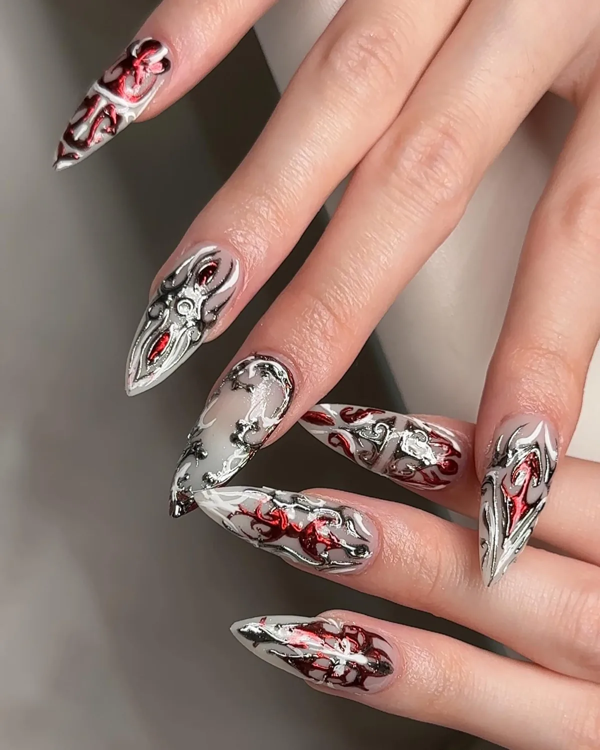 Long stiletto nails with silver chrome and red liner art